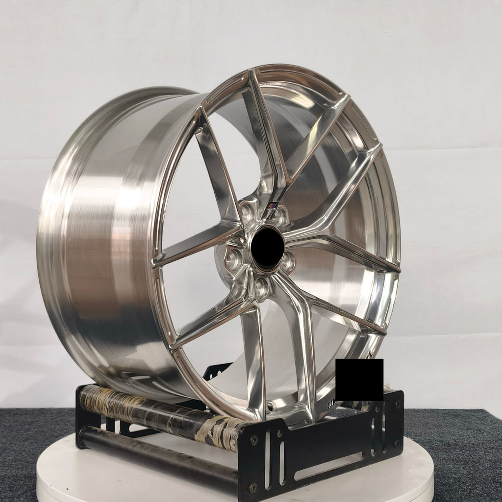 Chrome car wheel on a stand against a white background
