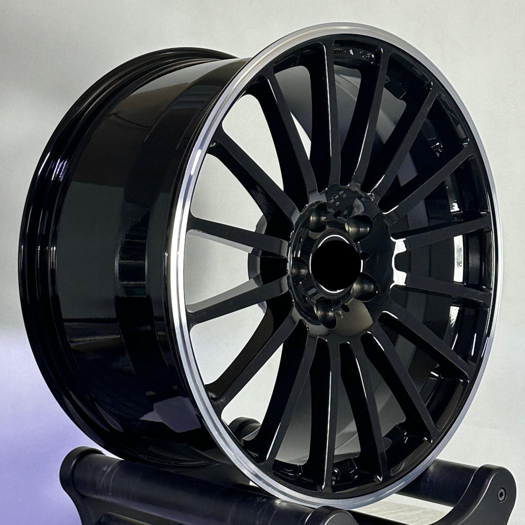 Black Mercedes-Benz car wheel on a stand against a neutral background