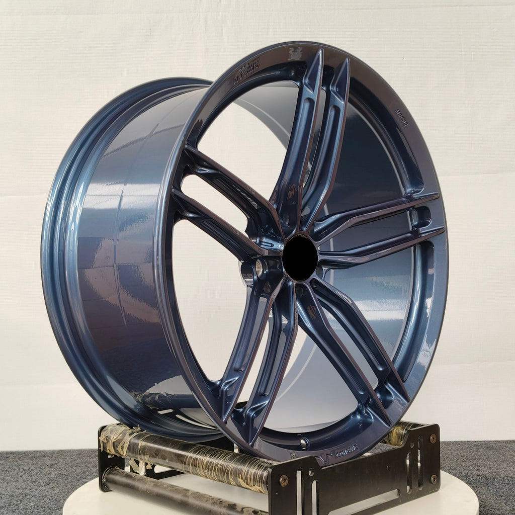 Blue car wheel rim on a white platform against a white background