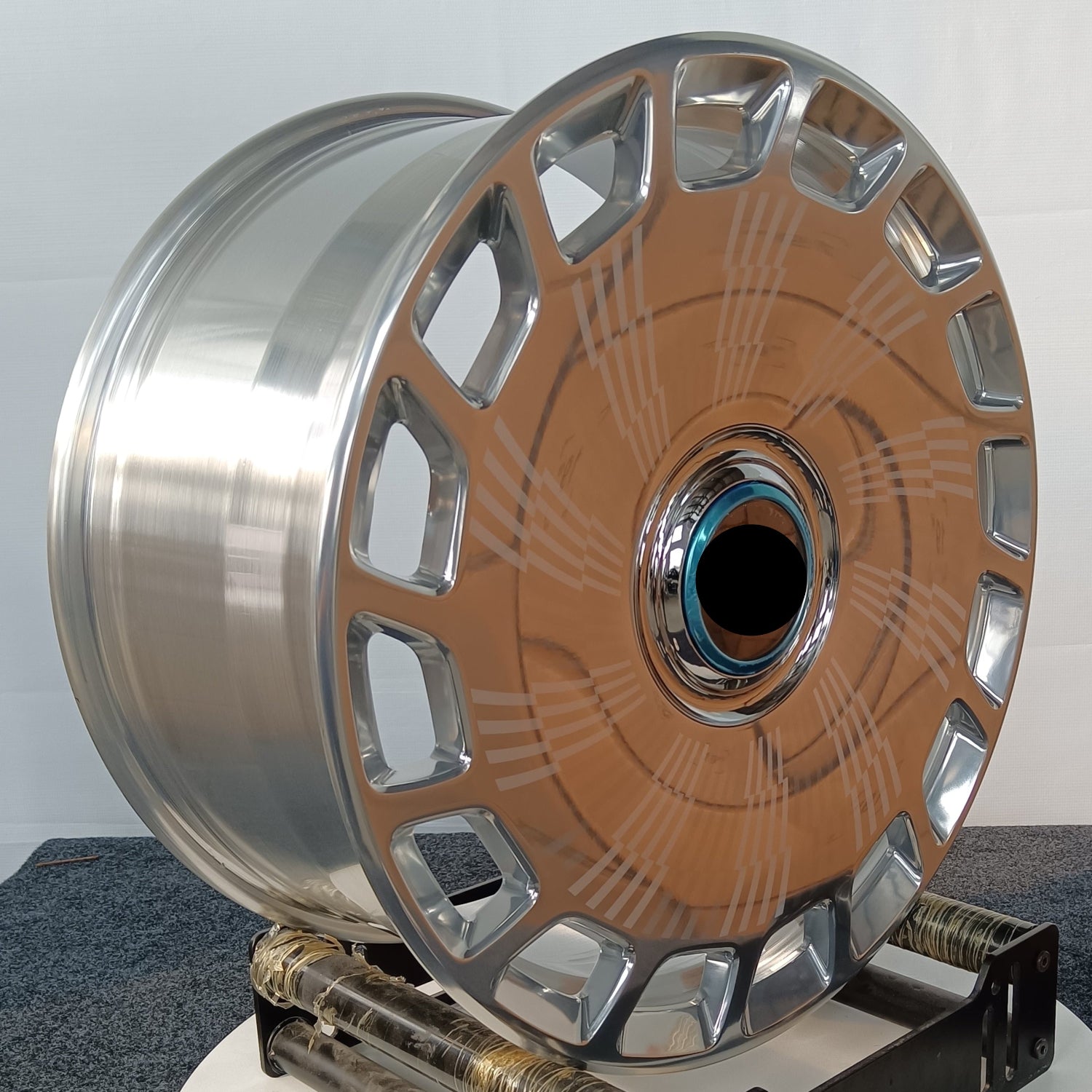 Decorative wheel with metallic finish on a white base against a gray background
